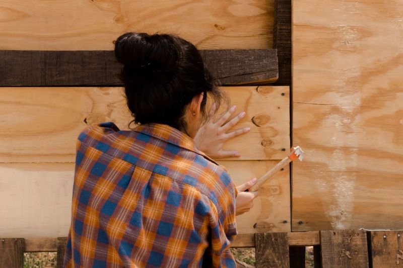 Handyman installing custom wood shelving in a bright home interior