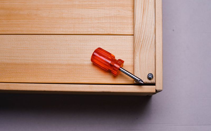 Local handyman repairing a cabinet door in a residential kitchen