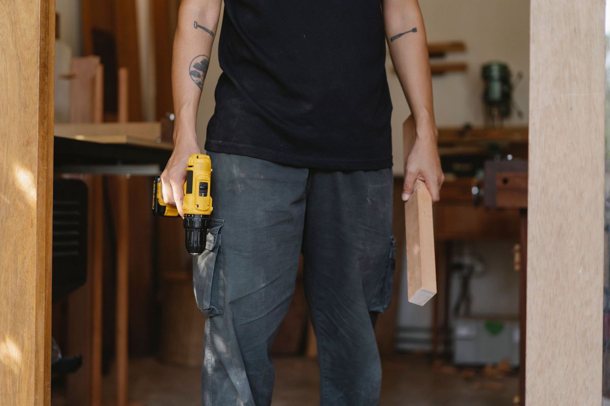 Handyman measuring and building custom wood shelving for a home