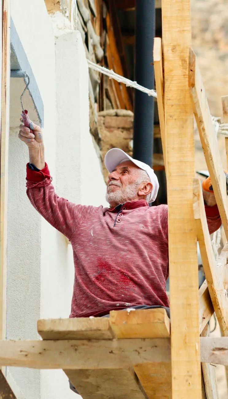 Handyman carefully painting interior wall trim in a Lake Oswego home
