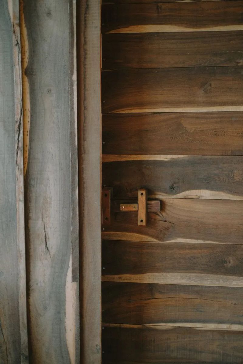 Handyman repairing a wooden backyard fence gate and hinges